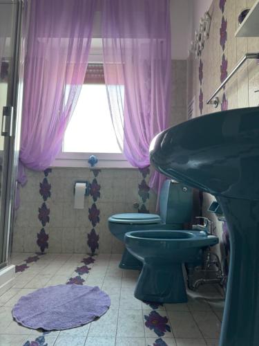 a bathroom with two toilets and a sink and a window at Green paradise with Etna view in Mascali