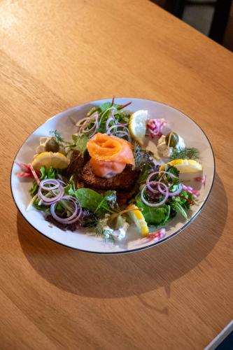 a plate of food on a wooden table at Hotel Restaurant Adler in Immenstaad am Bodensee