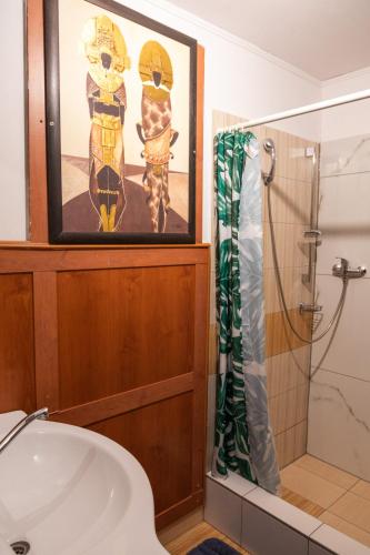 a bathroom with a shower and a painting on the wall at Dovolenkový dom Ela pets friendly in Poprad