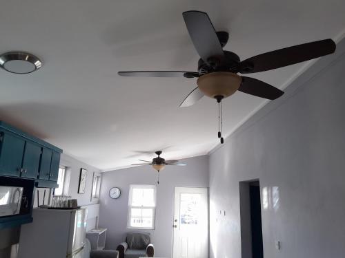 a ceiling fan in a living room with a kitchen at City View in Roseau