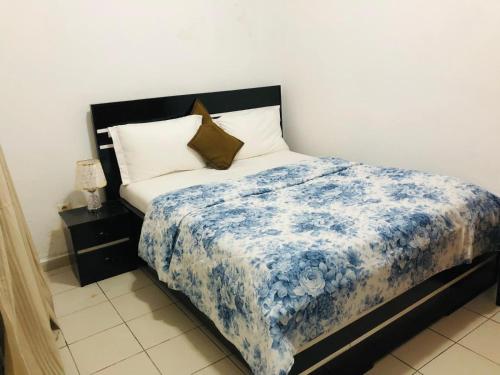 a bedroom with a bed with a blue and white blanket at BSA Douala in Douala
