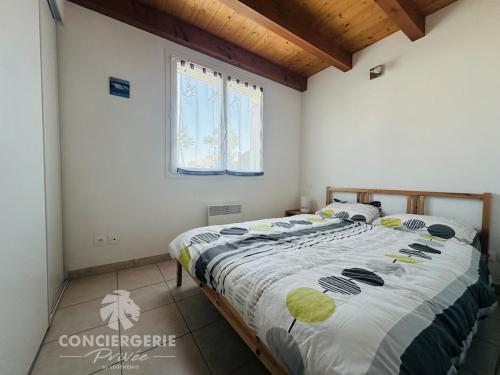 une chambre avec un grand lit dans une pièce dans l'établissement Maison de vacances à 50m de la plage, à Marennes