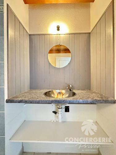 une salle de bain avec un lavabo et un miroir dans l'établissement Maison de vacances à 50m de la plage, à Marennes