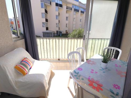 d'un balcon avec une table, une chaise, une table et une fenêtre. dans l'établissement Appartement 2 Pièces, 4 Couchages, Parking Privatif, à 100m de la Mer et des Commerces - FR-1-307-48, au Grau-du-Roi