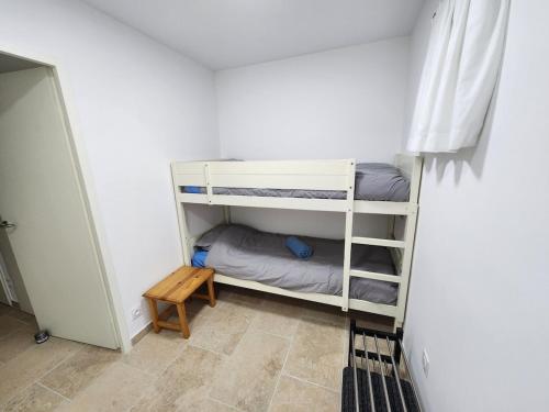 Cette petite chambre comprend 2 lits superposés et une table. dans l'établissement Nouveau Douceur à Bandol, à Bandol