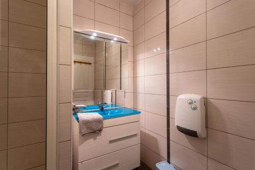 une salle de bain avec un lavabo bleu et un miroir dans l'établissement Gite Tété près de Lourdes, à Artigues