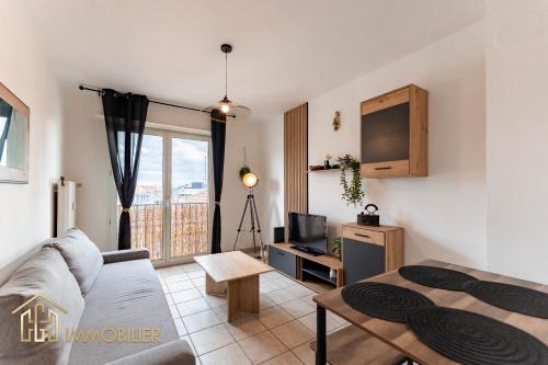 un salon avec un canapé et une télévision dans l'établissement Le Refuge - Colmar, à Colmar