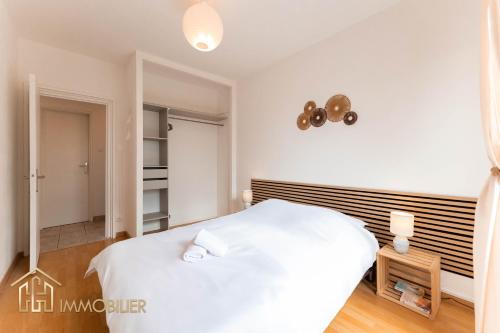 une chambre avec un lit blanc et un placard dans l'établissement Le Refuge - Colmar, à Colmar