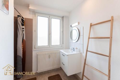 une salle de bain avec un lavabo et une fenêtre dans l'établissement Le Refuge - Colmar, à Colmar