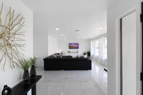 a living room with a black couch and white walls at Chic & modern canal-front retreat with private pool - Azure Tides in Punta Gorda
