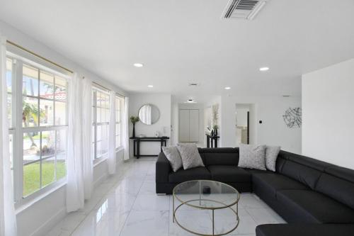 a living room with a black couch and a table at Chic & modern canal-front retreat with private pool - Azure Tides in Punta Gorda