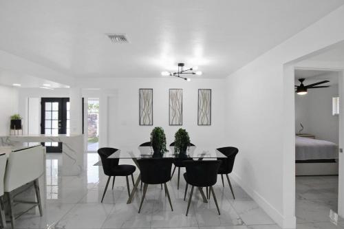 a white dining room with a table and chairs at Chic & modern canal-front retreat with private pool - Azure Tides in Punta Gorda