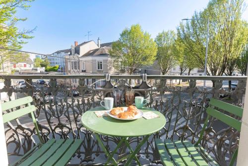 une table avec une assiette de nourriture sur un balcon dans l'établissement Le Solaris, Free Parking, 10 min SNCF Station, à Angers