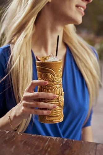 a woman holding a drink with a straw at Meltemi Blu - Adults Only in Perissa
