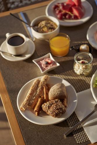 a table with a plate of food on a table at Meltemi Blu - Adults Only in Perissa