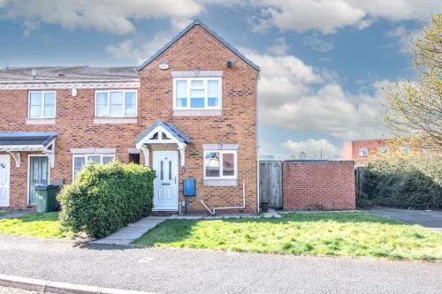 a brick house with a white door at Modern Two Bedroom House with Parking in Tipton