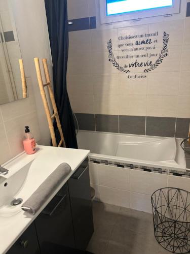 une salle de bain avec un lavabo et une baignoire dans l'établissement appartement proche centre ville quartier laennec, à Chalon-sur-Saône