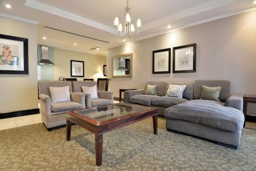 a living room with a couch and a coffee table at Raphael Suites in Johannesburg