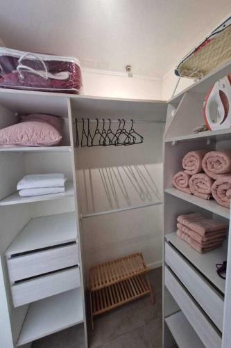 a walk in closet with white shelves and towels at Espectacular vista y ubicación in Santiago