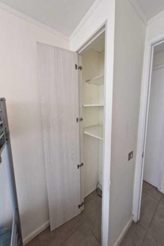 a white room with a closet with shelves at Espectacular vista y ubicación in Santiago