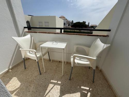 a balcony with two chairs and a table on it at Hostal Miramar in Los Caños de Meca