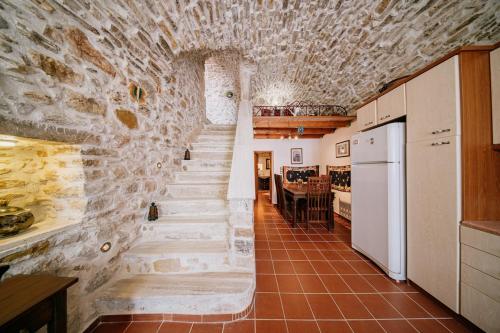 a staircase in a room with a stone wall at Traditional house in Kalamoti Agios Georgios in Kalamoti