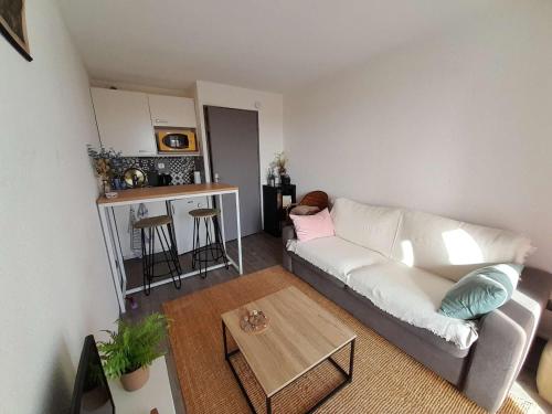 un salon avec un canapé blanc et une table dans l'établissement Studio proche plage avec balcon, petit garage et animaux admis - FR-1-324-561, à Saint-Hilaire-de-Riez