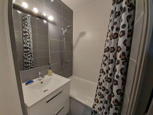 une salle de bain avec un lavabo et un rideau de douche dans l'établissement Studio proche plage avec balcon, petit garage et animaux admis - FR-1-324-561, à Saint-Hilaire-de-Riez
