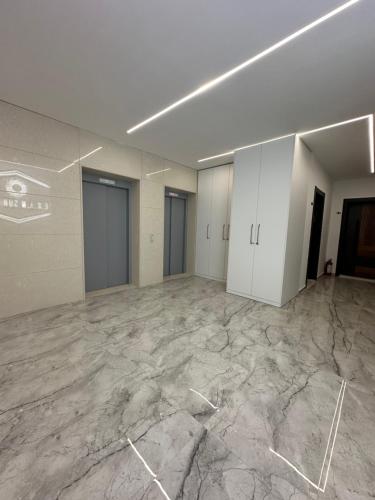an empty room with marble floors and white walls at EKAM Sun Apartments in Golem
