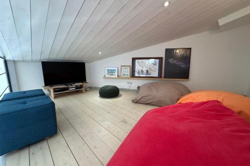 a living room with a flat screen tv and a couch at Architect-designed house close to beaches and shops in Rivedoux-Plage