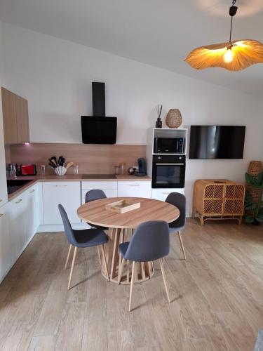 une cuisine avec une table et des chaises en bois dans l'établissement Appartement vue mer, à Grosseto-Prugna