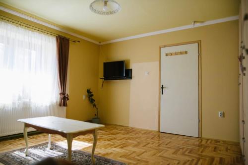 a living room with a table and a door at Roža Apartments in Subotica