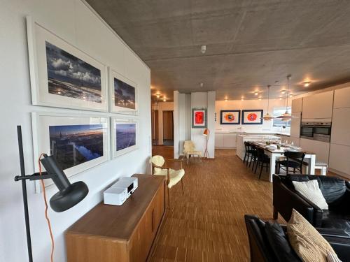 a living room with a kitchen and a dining room at Großzügiges modernes Ferienhaus in Neuharlingersiel