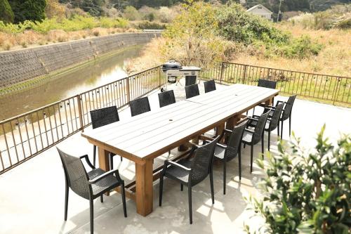 a wooden table and chairs on a deck next to a river at 興津ビーチサイドヴィラ 勝浦 - Okitsu Beachside Villa - Katsuura in Katsuura