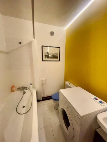 une salle de bain avec une baignoire, des toilettes et un lavabo dans l'établissement Geneva Residences - Colourful Apartment by the border, à Ferney-Voltaire