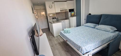 Cette petite chambre comprend un lit et une cuisine. dans l'établissement joli studio refait a neuf, à Bormes-les-Mimosas
