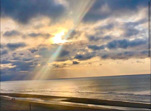 - un arc en ciel au-dessus d'une plage avec l'océan dans l'établissement Appartement, à Bray-Dunes