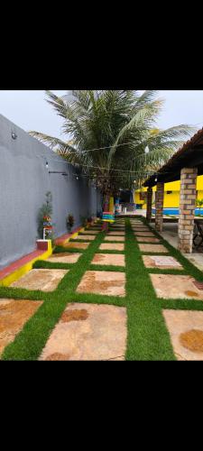 un giardino con prato e palme in un edificio di Casa praia peito de moca a Luis Correia