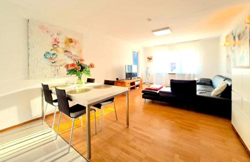 ein Wohnzimmer mit Tisch und Couch in der Unterkunft Art & Living Apartment I nähe Frankfurt I Messe in Schöneck