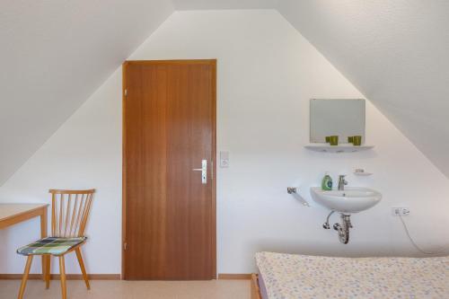 a bathroom with a sink and a wooden door at Unterfalkenhof in Schramberg