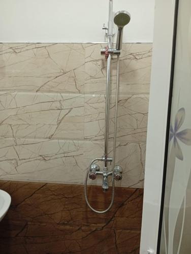 a shower in a bathroom with a marble wall at Shan Villa in Negombo