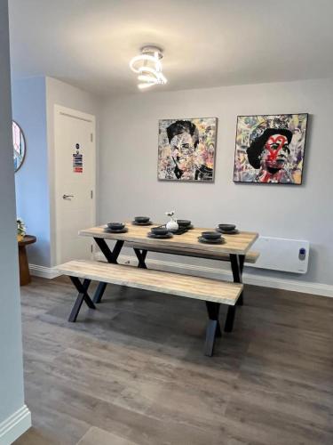 a table in a room with paintings on the wall at A Cozy Magical Retreat at Knightwood Oak, New Forest in Ower