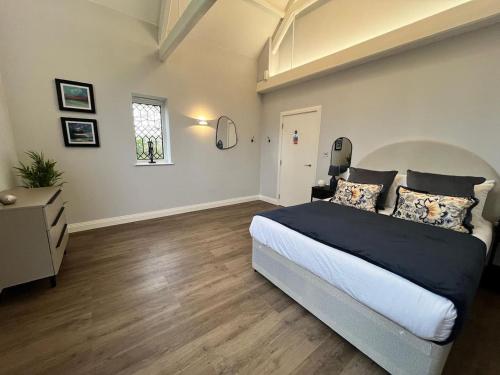 a bedroom with a large bed and a window at A Cozy Magical Retreat at Knightwood Oak, New Forest in Ower