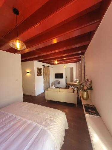 a bedroom with a white bed and a couch at Het Waterhof in Leiden