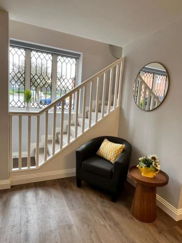 a living room with a chair and a staircase at A Cozy Magical Retreat at Knightwood Oak, New Forest in Ower