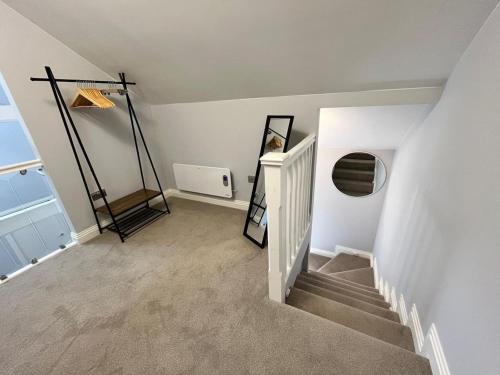 a room with a staircase with a mirror and a window at A Cozy Magical Retreat at Knightwood Oak, New Forest in Ower