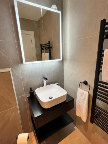 a bathroom with a sink and a mirror at A Cozy Magical Retreat at Knightwood Oak, New Forest in Ower