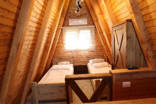 a room with two beds in a wooden cabin at Magareće Mleko Eko Farma Sisevac Wellness&Spa in Paraćin
