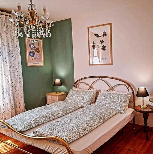 ein Schlafzimmer mit einem Bett und einem Kronleuchter in der Unterkunft Pupili's in Calalzo