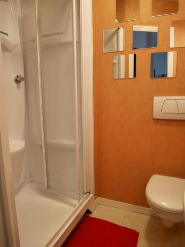 une salle de bain avec douche et un tapis rouge dans l'établissement appartement chic et calme en plein centre-ville, à Paimpol